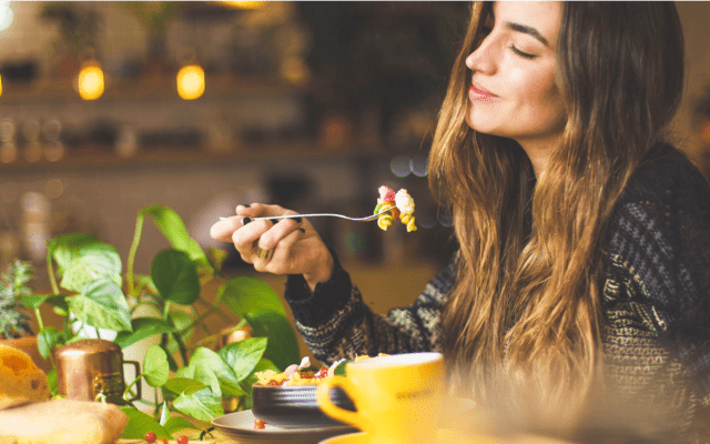 Une jeune femme mange au restaurant qu'elle a découvert grâce à Instagram